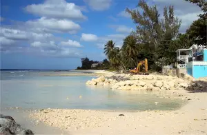 A small ocean pool forms as a bulldozer continues work in the background