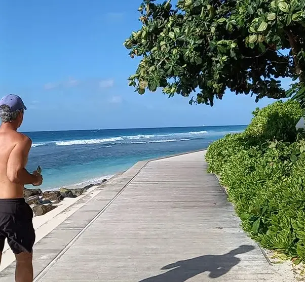 Man jogging along the boardwalk on a bright sunny day