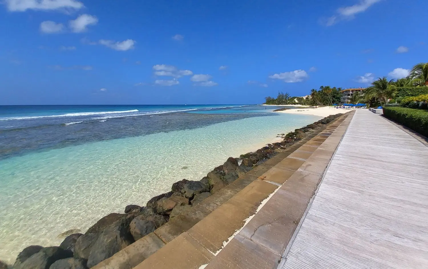 Panoramic view of the boardwalk with the vivid ocean and shallow pools on the left