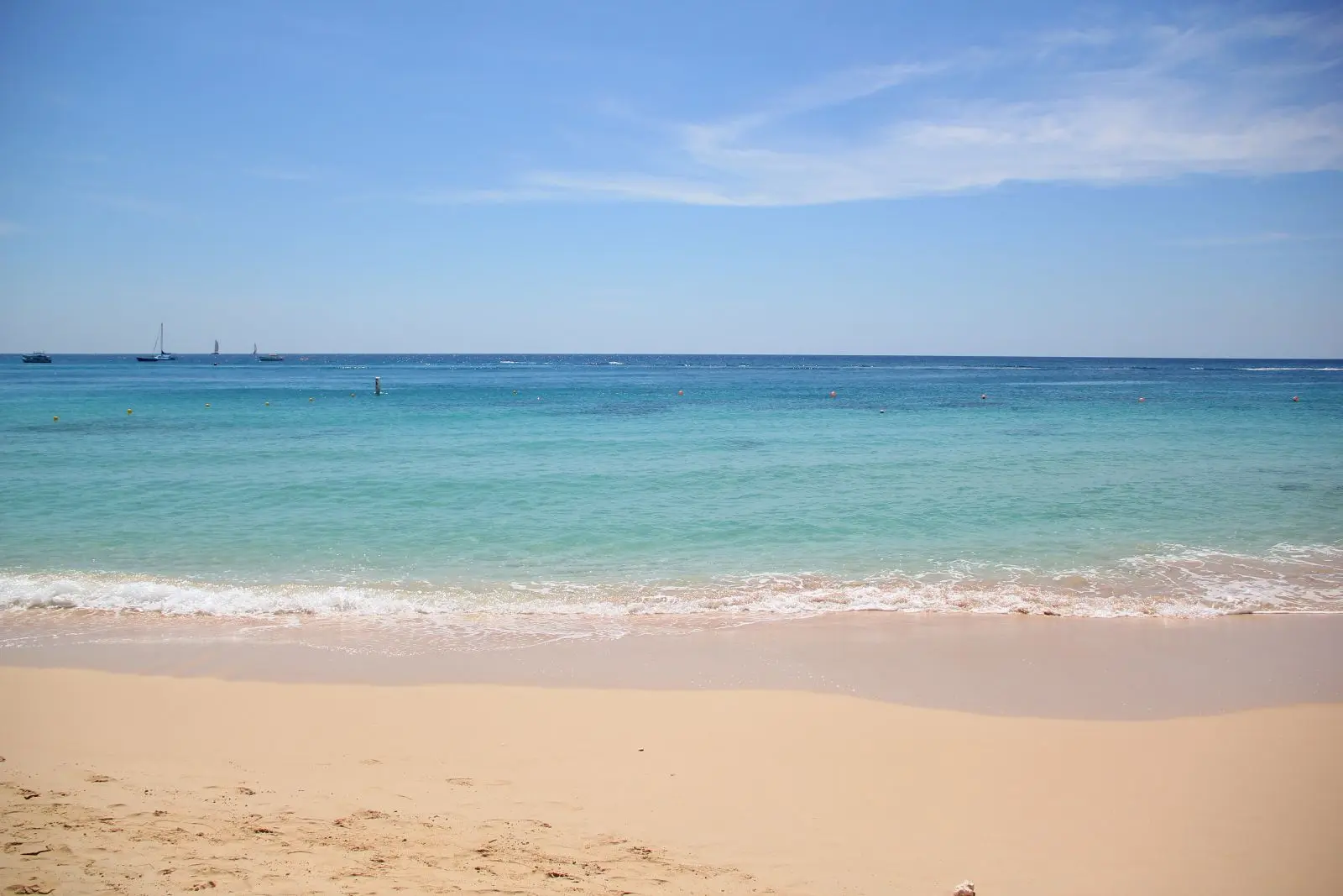 View out to sea over turquoise waters from the white-sand beach at Holetown