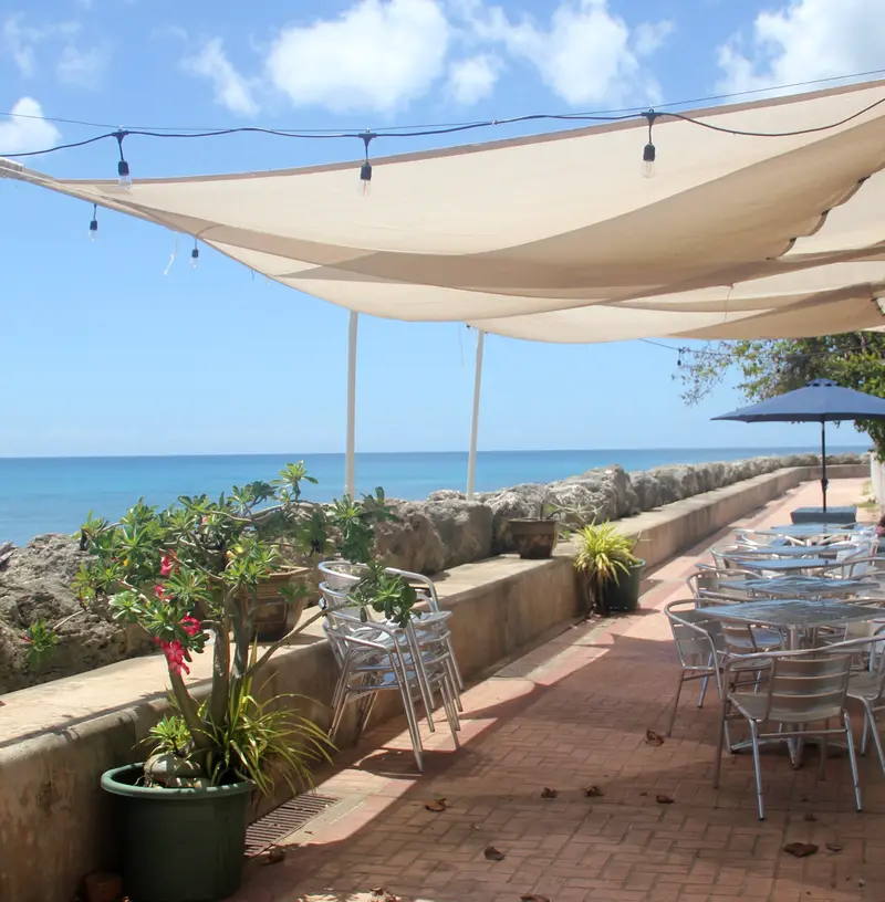 Boardwalk cafe with awning, tables and chairs with oceanfront views