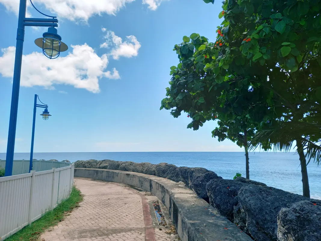 The start of the boardwalk with historic lighting fixtures and ocean view ahead.