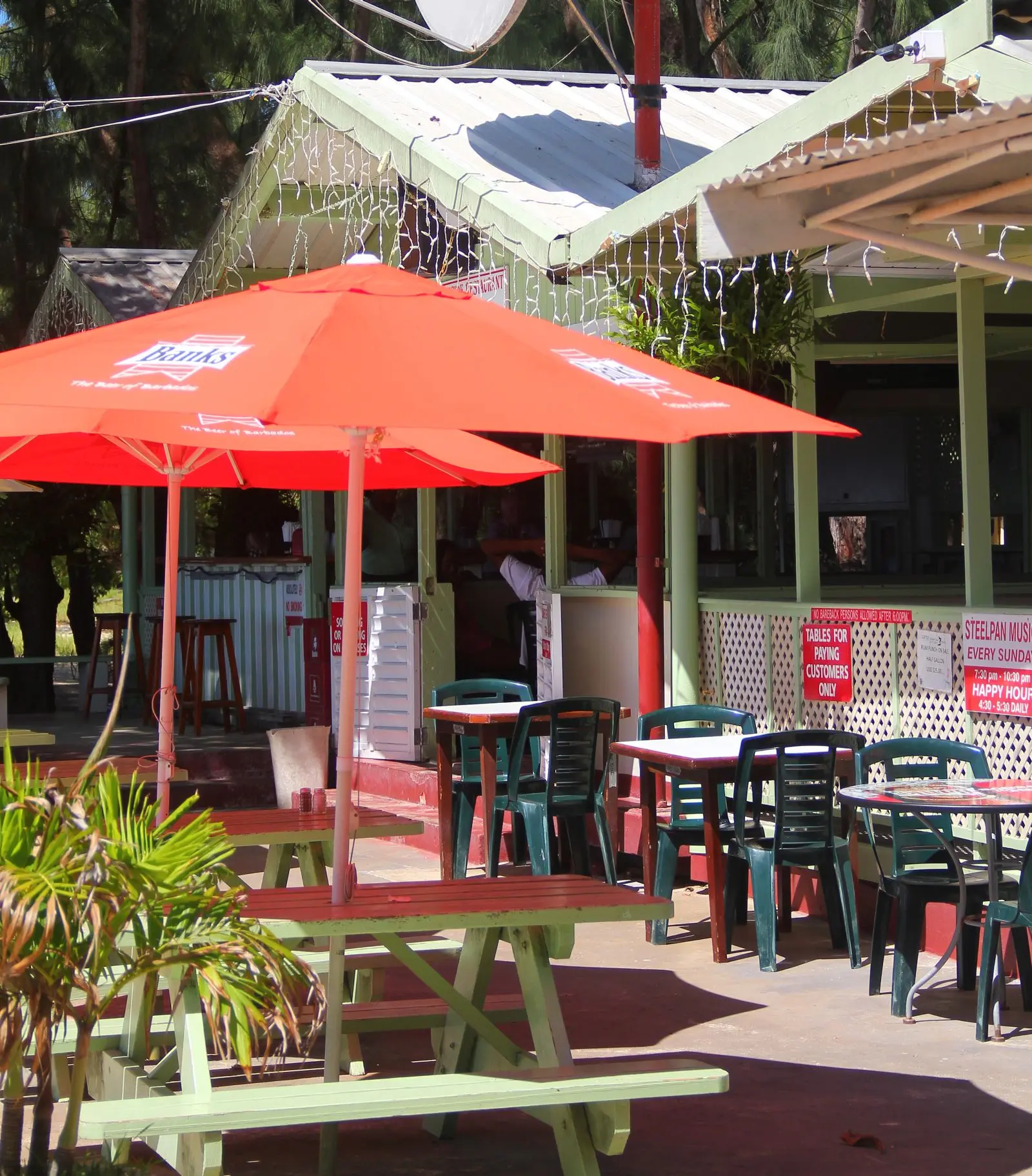 Picnic table shaded by colorful umbrella on the beach at Surfside Restaurant