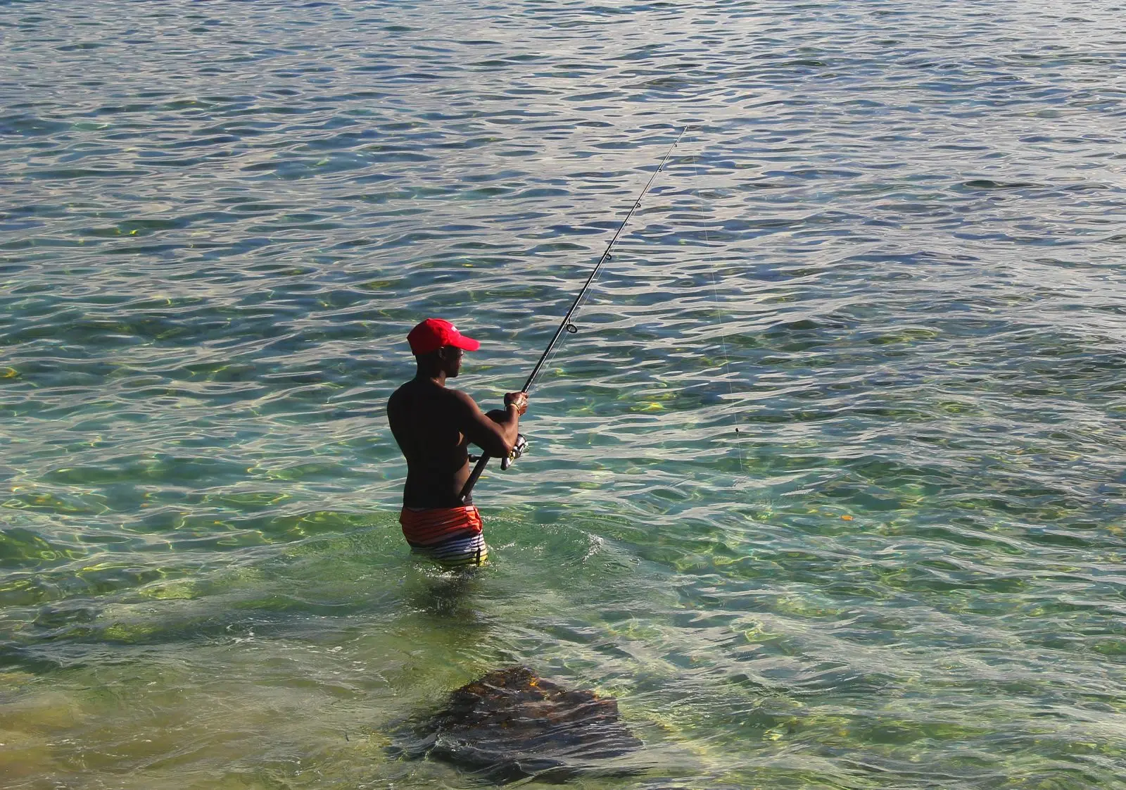 Bajan fisherman with his line just off the boardwalk